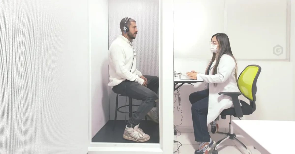 Cabina de audiometría con paciente y profesional de la salud